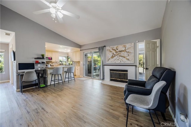 30681 Southern Cross Rd, Temecula, CA 92592 - living room with a brick fireplace, light wood-type flooring, ceiling fan, baseboards, and high vaulted ceiling