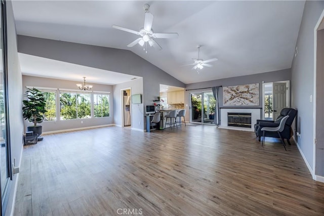 30681 Southern Cross Rd, Temecula, CA 92592 - living area with a chandelier, lofted ceiling, a glass covered fireplace, wood finished floors, and healthy amount of natural light