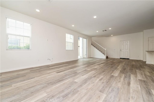 5961 Silveira St, Eastvale, CA 92880 - unfurnished living room featuring light wood-style flooring, recessed lighting, stairs, and baseboards