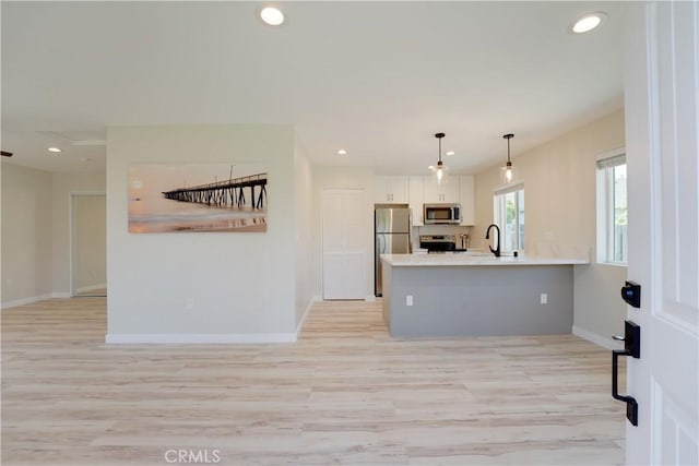10319 Hemphill Ct, San Diego, CA 92126 - kitchen featuring stainless steel appliances, a sink, a peninsula, baseboards, and white cabinets