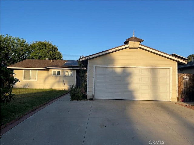 view of front of home featuring solar panels, driveway, and a front lawn