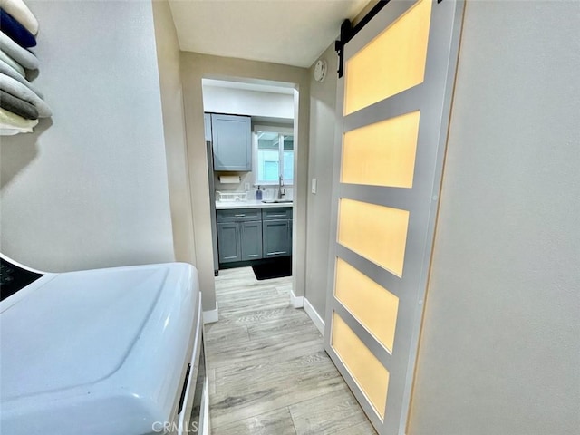 738 N Fairhaven St, Anaheim, CA 92801 - corridor with light wood-style floors, a sink, baseboards, and a barn door