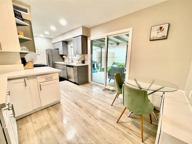 738 N Fairhaven St, Anaheim, CA 92801 - kitchen featuring stainless steel appliances, a sink, light wood finished floors, open shelves, and recessed lighting
