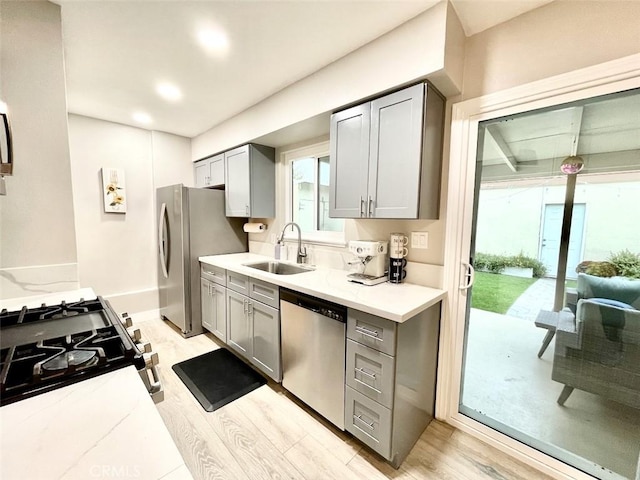 738 N Fairhaven St, Anaheim, CA 92801 - kitchen featuring stainless steel appliances, a sink, gray cabinets, light countertops, and light wood-style floors