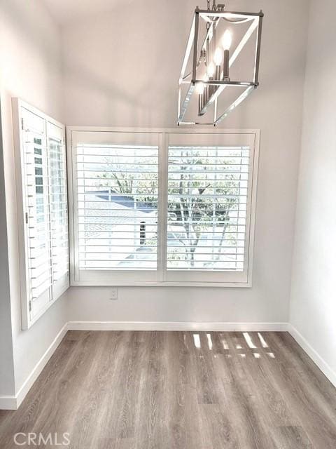 1428 Brett Pl Unit 86, San Pedro, CA 90732 - unfurnished dining area with a chandelier, wood finished floors, and baseboards