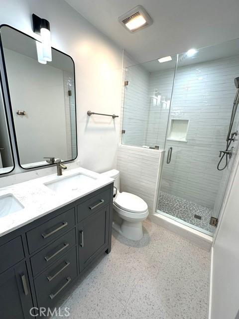 1428 Brett Pl Unit 86, San Pedro, CA 90732 - bathroom with toilet, a shower stall, double vanity, and speckled floor