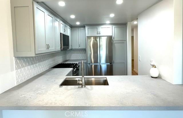 1428 Brett Pl Unit 86, San Pedro, CA 90732 - kitchen with stainless steel appliances, tasteful backsplash, a sink, light countertops, and recessed lighting