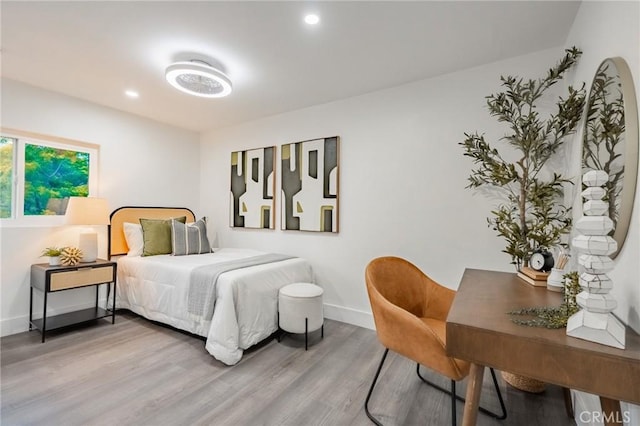 bedroom with wood finished floors, baseboards, and recessed lighting