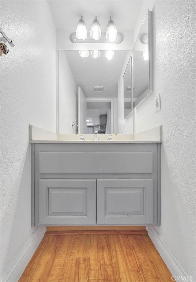 1207 Porto Grande Unit 1, Diamond Bar, CA 91765 - bathroom featuring vanity, wood finished floors, a textured wall, and baseboards