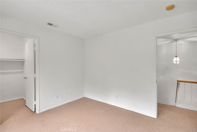 1207 Porto Grande Unit 1, Diamond Bar, CA 91765 - unfurnished bedroom with light colored carpet, a walk in closet, a textured ceiling, baseboards, and a closet