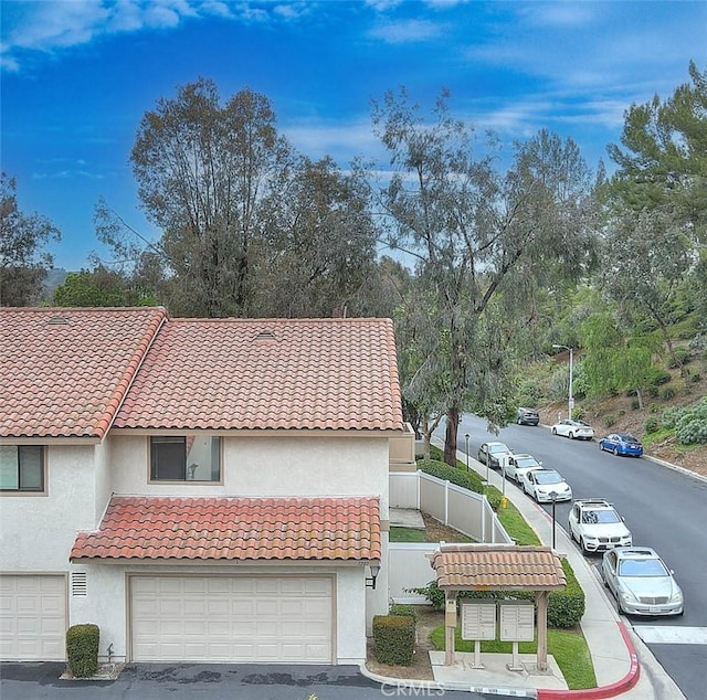 1207 Porto Grande Unit 1, Diamond Bar, CA 91765 - view of front of property with stucco siding, fence, a tile roof, and an attached garage