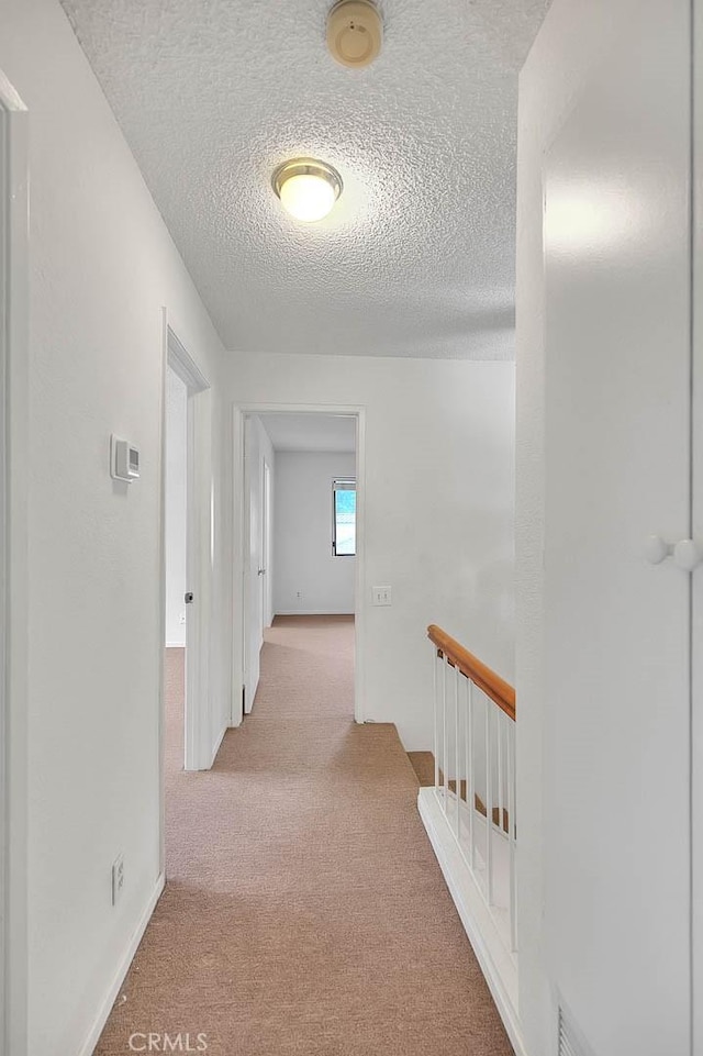 1207 Porto Grande Unit 1, Diamond Bar, CA 91765 - hallway featuring carpet floors, a textured ceiling, an upstairs landing, and baseboards
