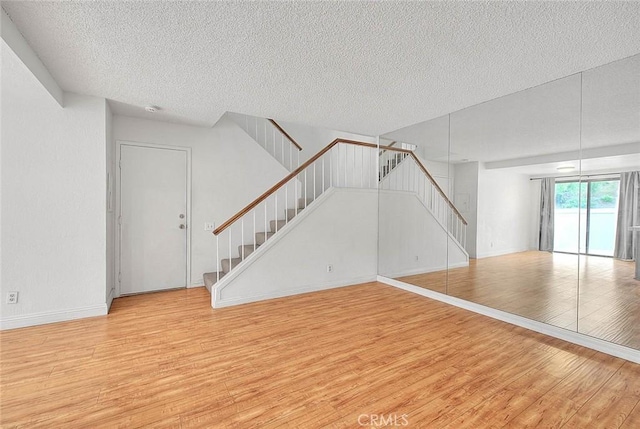 1207 Porto Grande Unit 1, Diamond Bar, CA 91765 - unfurnished living room with a textured ceiling, stairway, and wood finished floors
