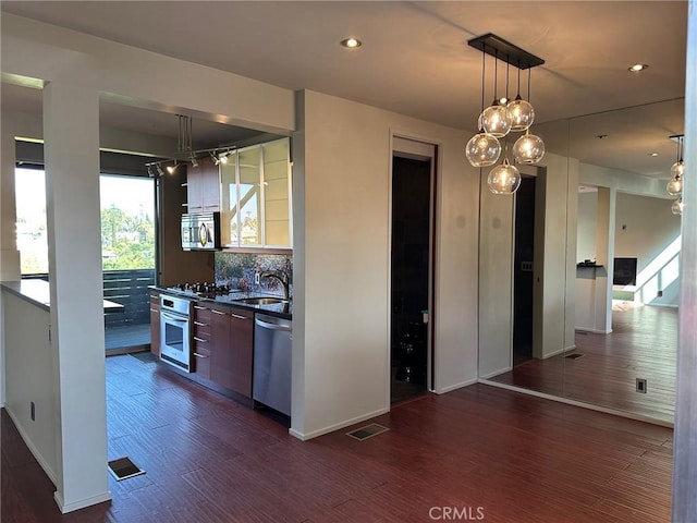 1419 Angelus Ave, Los Angeles, CA 90026 - kitchen featuring appliances with stainless steel finishes, dark countertops, dark wood finished floors, decorative backsplash, and modern cabinets