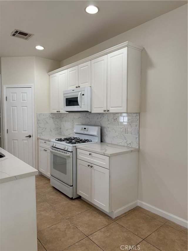 kitchen featuring white appliances, tasteful backsplash, white cabinets, and recessed lighting