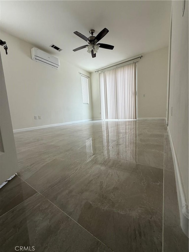 unfurnished room with a wall mounted air conditioner, a ceiling fan, and baseboards