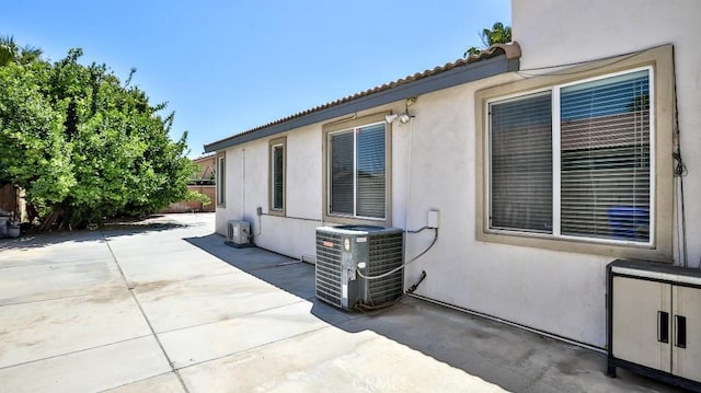 view of patio with central air condition unit and fence