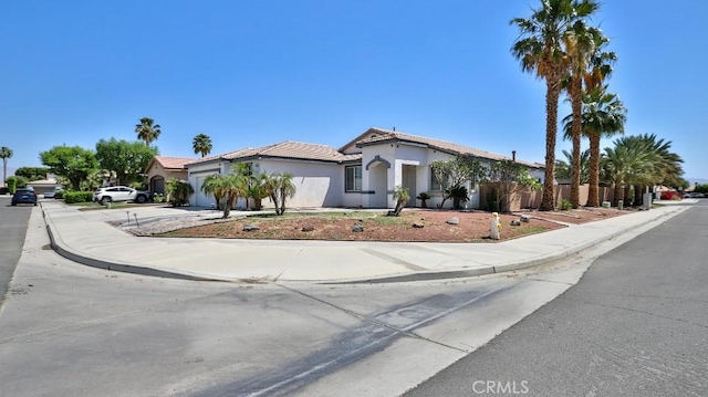 mediterranean / spanish house featuring concrete driveway, an attached garage, and stucco siding