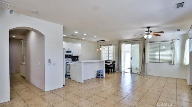 kitchen featuring white appliances, arched walkways, a ceiling fan, recessed lighting, and white cabinetry
