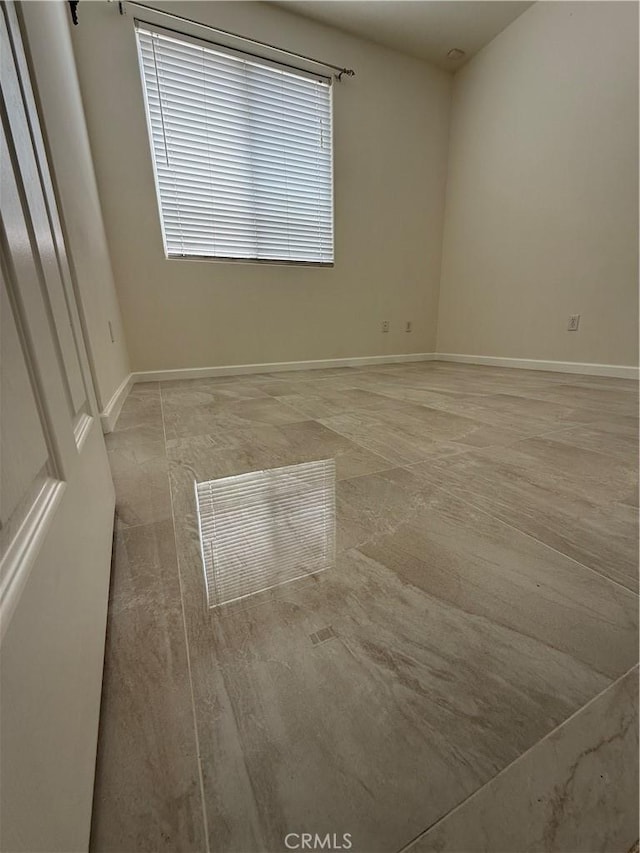 unfurnished room featuring baseboards