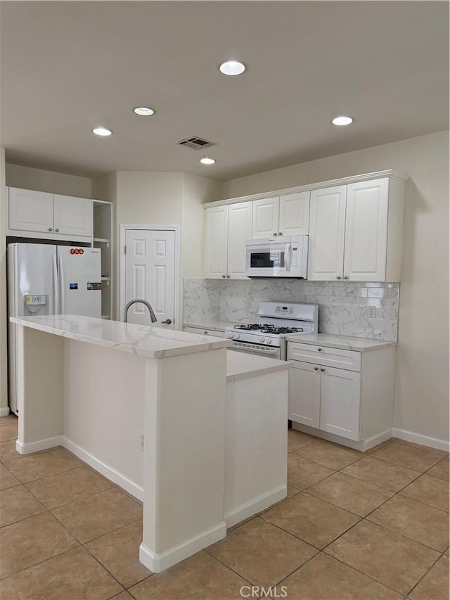 kitchen with white appliances, light tile patterned floors, tasteful backsplash, white cabinets, and recessed lighting