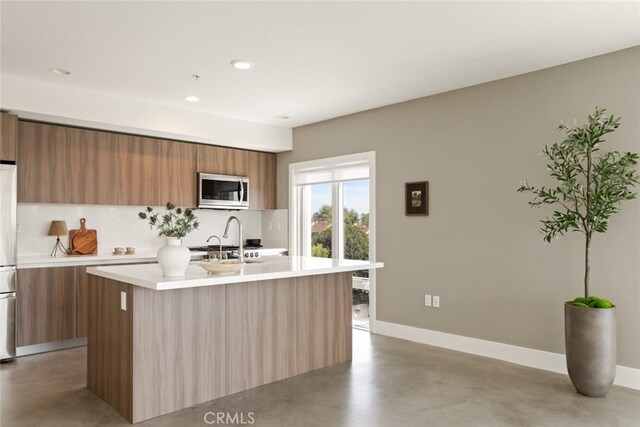 482 S Arroyo Pkwy Unit 408, Pasadena, CA 91105 - kitchen with stainless steel microwave, modern cabinets, finished concrete floors, light countertops, and brown cabinetry
