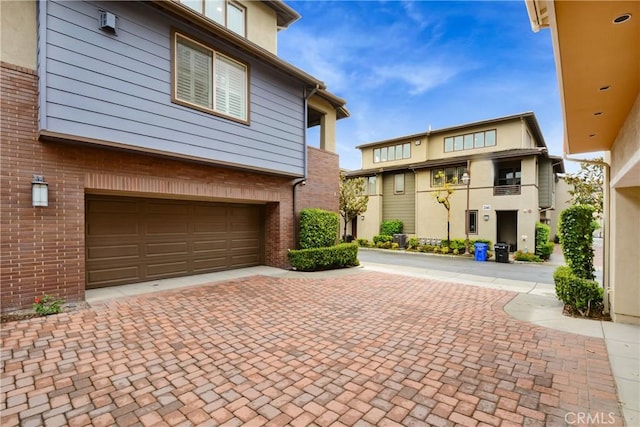 12474 Benton Dr Unit 2, Rancho Cucamonga, CA 91739 - view of front of house with brick siding, an attached garage, and decorative driveway