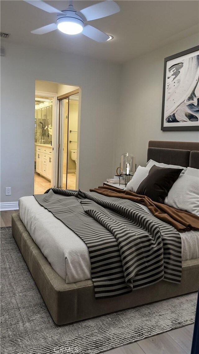 bedroom with wood finished floors, ensuite bathroom, ceiling fan, and baseboards