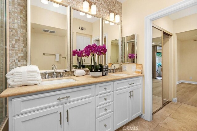 bathroom with double vanity and tile patterned floors