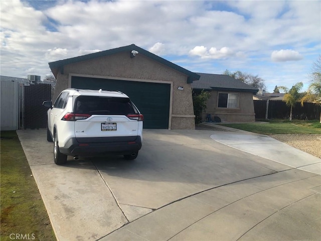 single story home featuring concrete driveway, an attached garage, and stucco siding