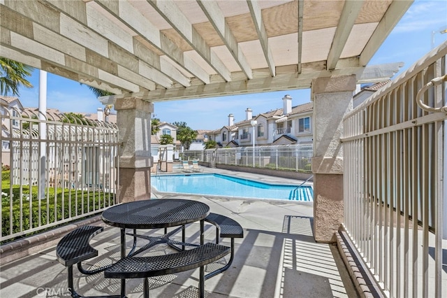community pool with fence, a residential view, and a patio area