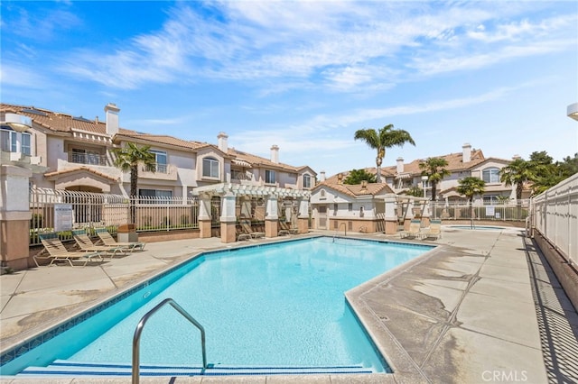community pool featuring a residential view, fence, a patio area, and a pergola