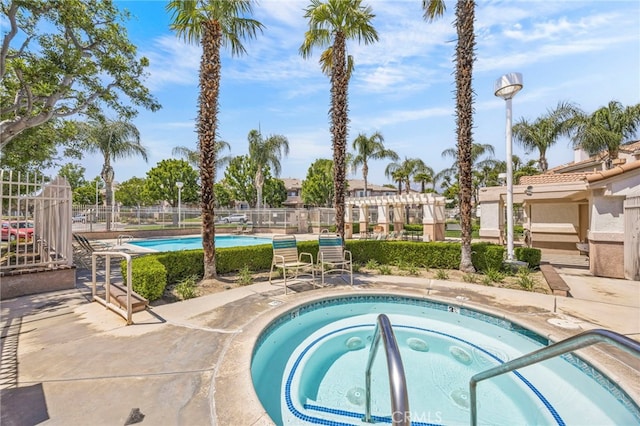 community pool with fence and a community hot tub