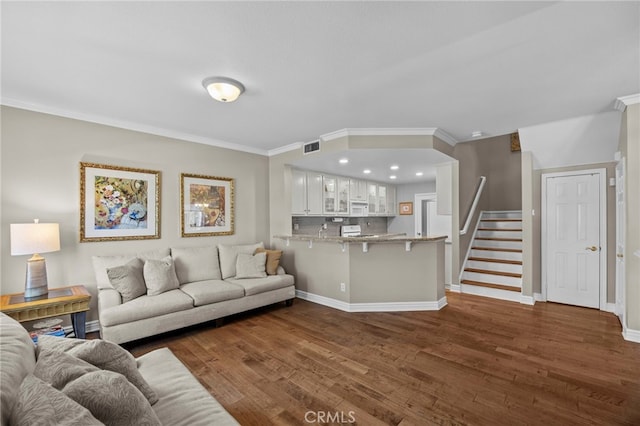 living area with dark wood-style floors, ornamental molding, baseboards, and stairs