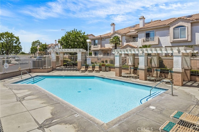 community pool featuring a pergola, fence, and a patio area