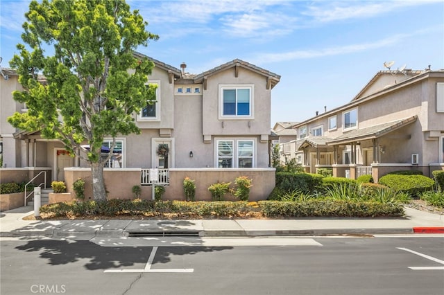 view of property featuring stucco siding, fence, and a residential view