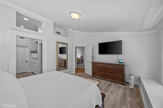 bedroom with ornamental molding, baseboards, wood finished floors, vaulted ceiling, and ensuite bathroom