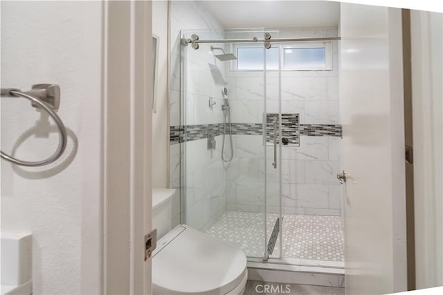 bathroom featuring toilet and a stall shower