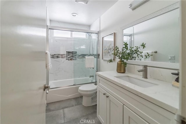 full bath featuring toilet, bath / shower combo with glass door, and vanity