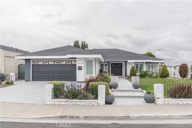 single story home with an attached garage, concrete driveway, fence, and a shingled roof