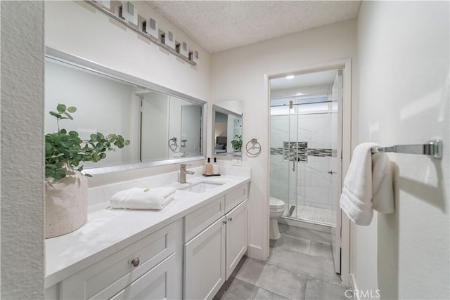 full bath featuring a shower stall, toilet, vanity, and a textured ceiling