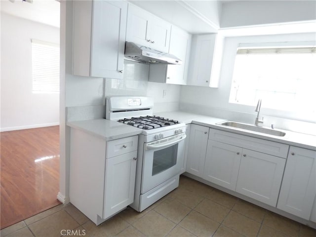 612 San Gabriel Blvd, Rosemead, CA 91770 - kitchen featuring under cabinet range hood, white range with gas stovetop, a sink, light countertops, and white cabinetry