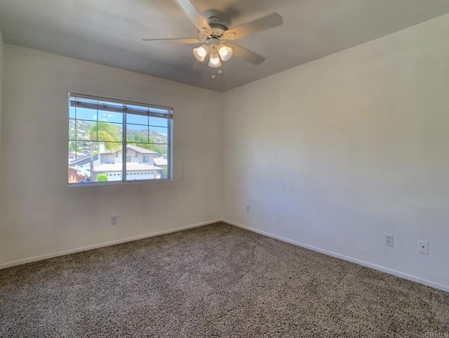 spare room featuring carpet floors, a ceiling fan, and baseboards