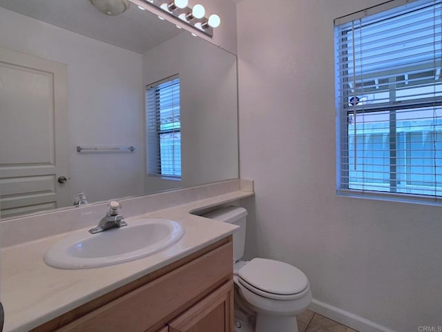 bathroom featuring vanity, tile patterned flooring, toilet, and baseboards