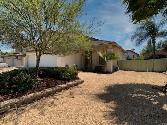 view of front of home featuring stucco siding, a garage, fence, a gate, and concrete driveway