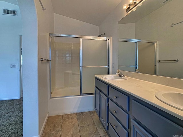 bathroom featuring double vanity, baseboards, enclosed tub / shower combo, and lofted ceiling
