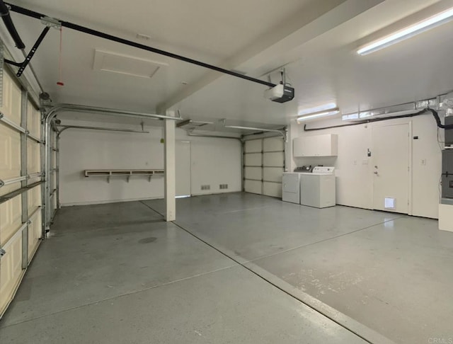garage featuring separate washer and dryer and a garage door opener