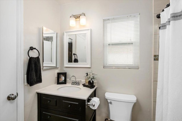 full bathroom with toilet, vanity, and curtained shower