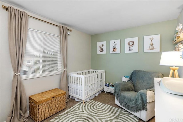 bedroom featuring carpet flooring and a crib