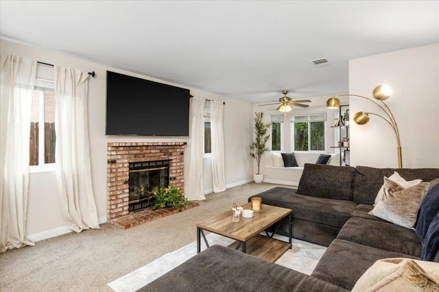 living area with ceiling fan, carpet floors, a brick fireplace, and baseboards